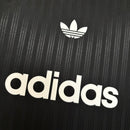 Camiseta hombre Adidas Adicolor Poly negra original tres bandas blancas logotipo trébol bordado estilo retro urbano streetwear deportiva.