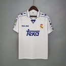 Camiseta oficial del Real Madrid primera equipación temporada 1996 1997 blanca retro para hombre de Tienda Hincha Futbolero, diseño legendario de Raúl y Roberto Carlos, Camiseta Real Madrid retro, Real Madrid 96/97, Ropa Real Madrid vintage, Comprar camiseta Real Madrid blanca, Raúl González Madrid, Roberto Carlos, Madridistas, Merengues, Camisetas fútbol retro, Retro Real Madrid 1997, Historia Real Madrid, Colección Madrid, Fútbol años 90.