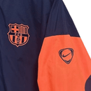 Chaqueta cortaviento hombre FC Barcelona 2025 2026 diseño T90 azul marino detalles naranja sin capucha entrenamiento oficial fútbol culé 25/26 impermeable.