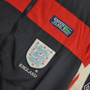 Inglaterra retro, Cortaviento Inglaterra oficial, Chaqueta Inglaterra azul marino, Ropa vintage Inglaterra, Windbreaker fútbol hombre, Regalo fútbol hombre Inglaterra, Chaqueta azul retro, England heritage kit, Inglaterra lifestyle, Comprar cortaviento barato, Tienda Hincha Futbolero.