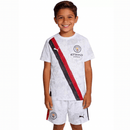 Conjunto infantil Manchester City tercera equipación 2025 2026 niños kit completo camiseta blanca y pantalón corto oficial fútbol niños City 25/26 vista frontal.